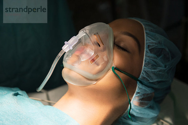 Patient mit Sauerstoffmaske im Operationssaal