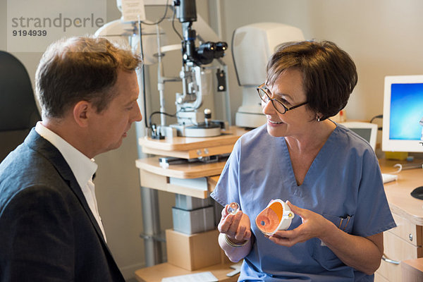 Optikerin im Gespräch mit Patientin in der Klinik