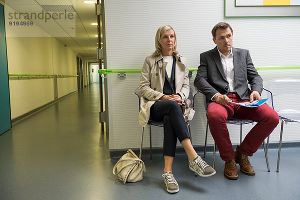 Paar im Wartebereich eines Krankenhauses sitzend
