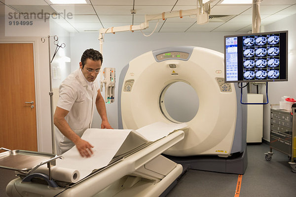 Männlicher Arzt bei der Vorbereitung eines medizinischen MRT-Scanners im Krankenhaus