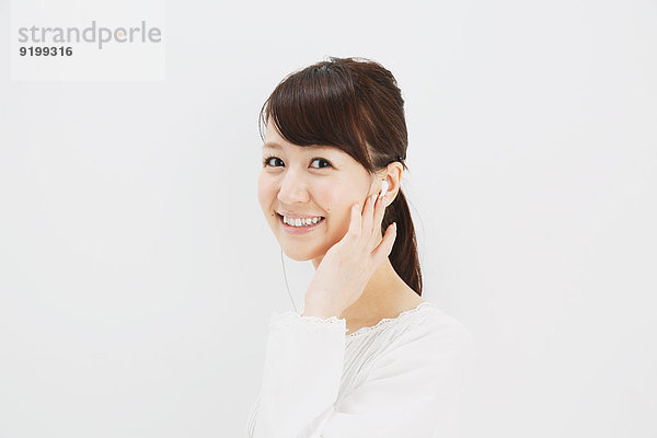 stehend junge Frau junge Frauen weiß Hemd Hintergrund Jeans Kopfhörer japanisch