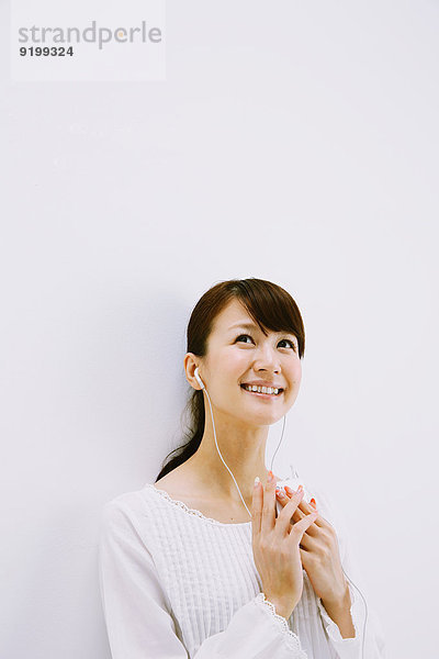 stehend junge Frau junge Frauen weiß Hemd Hintergrund Jeans Kopfhörer japanisch