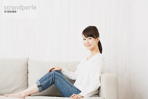 junge Frau junge Frauen Couch weiß Hemd Jeans japanisch