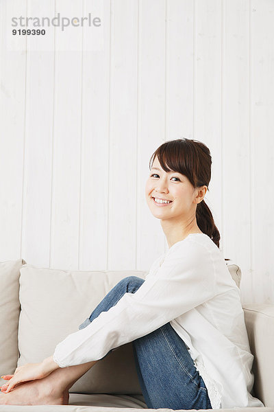junge Frau junge Frauen Couch weiß Hemd Jeans japanisch