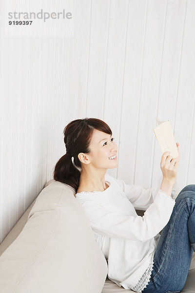 junge Frau junge Frauen Couch Buch weiß Hemd Jeans Taschenbuch japanisch