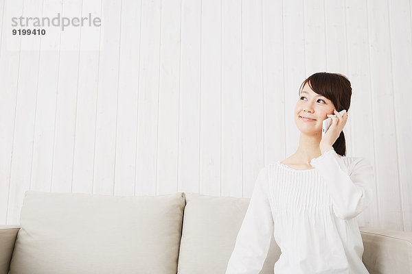 junge Frau junge Frauen Couch weiß Hemd japanisch Smartphone