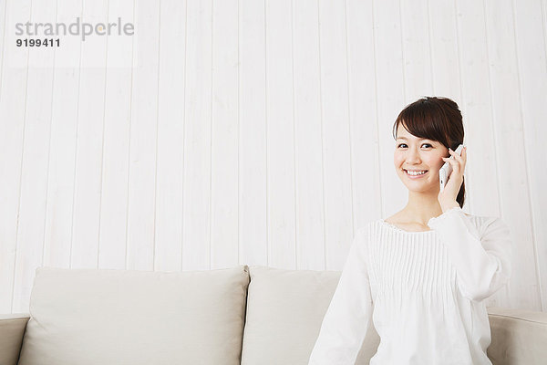 junge Frau junge Frauen Couch weiß Hemd japanisch Smartphone