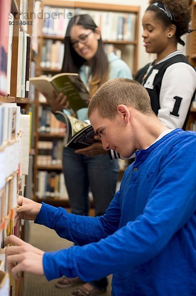 Studenten wählen Bücher in der Bibliothek aus