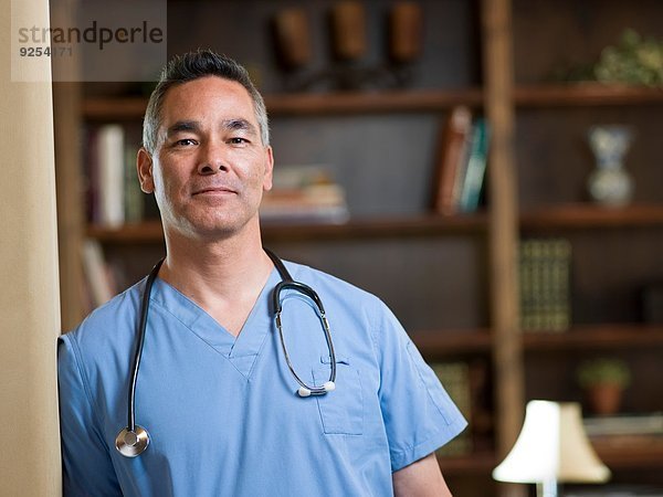 Porträt eines lächelnden reifen Arztes in der Praxis