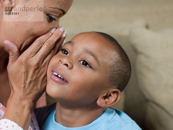 Nahaufnahme der reifen Mutter  die dem Sohn zuflüstert