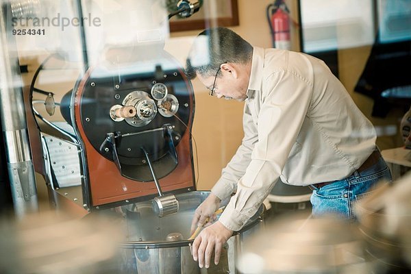 Reifer Mann mit Kaffeerösterei im Cafe