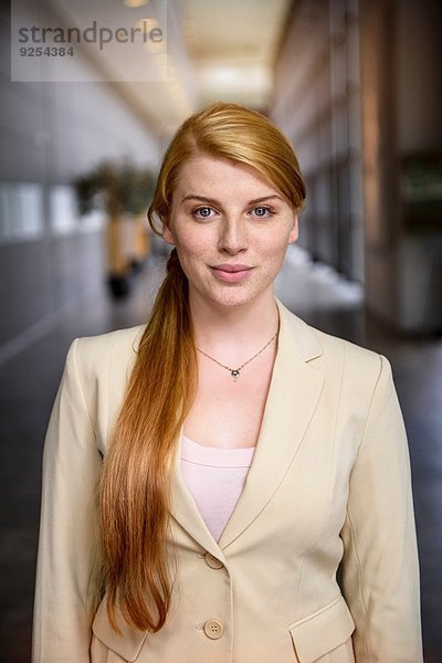 Porträt einer selbstbewussten jungen Geschäftsfrau im Büroflur