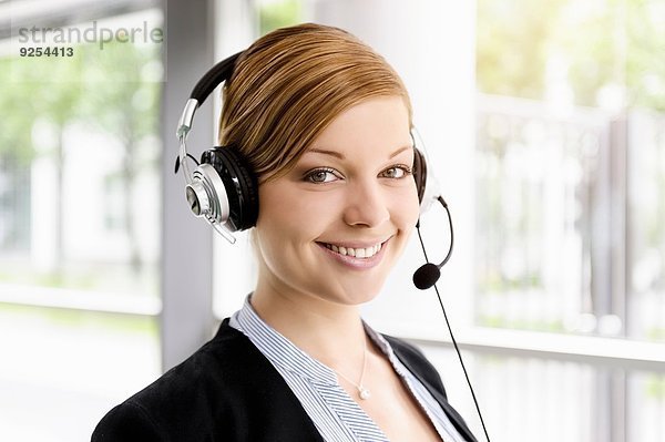 Portrait der jungen Geschäftsfrau im Telefon-Headset
