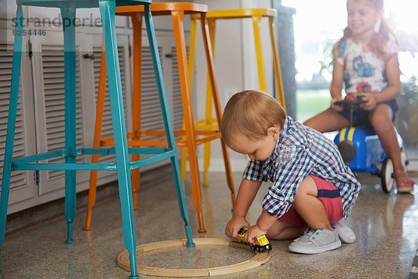 Männliches Kleinkind und Schwester spielen in der Küche