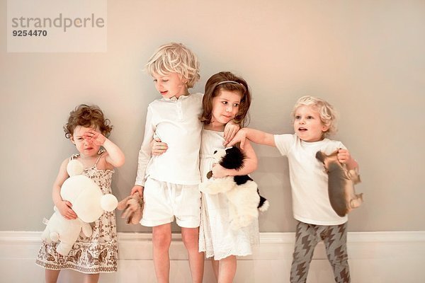 Porträt von vier kleinen Kindern in Folge  eines weint