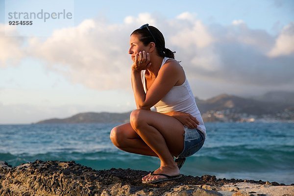 Mittlere erwachsene Frau  die vom Pier  Spice Island Beach Resort  Grenada  auf das karibische Meer blickt