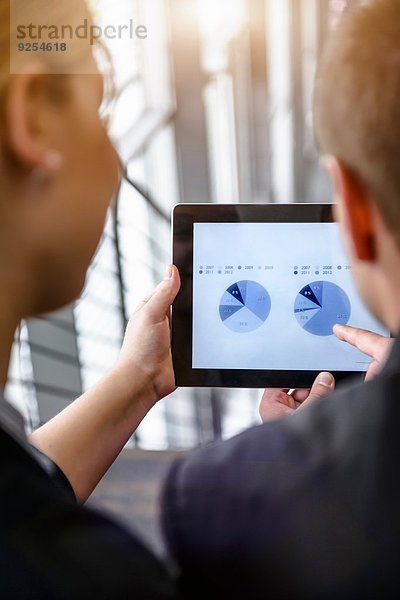 Über-Schulter-Ansicht von Geschäftsfrau und Mann mit Touchscreen auf digitalem Tablett im Büro