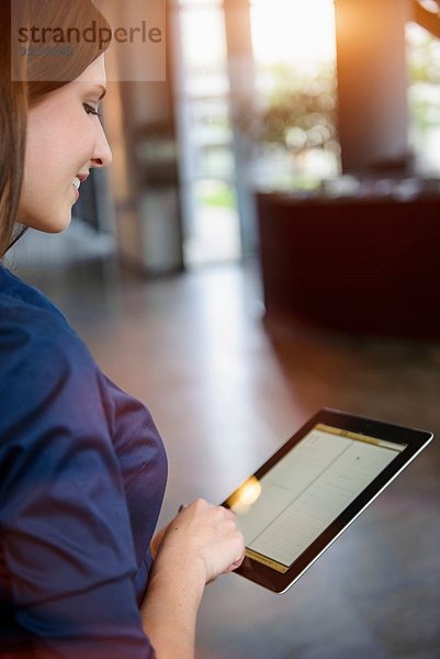 Ausschnitt einer jungen Geschäftsfrau mit digitalem Tablett im Büro