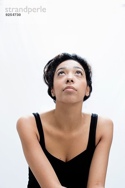 Studio-Porträt einer ruhigen jungen Frau mit Blick nach oben