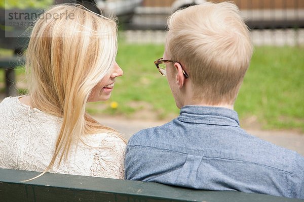 Über die Schulteransicht des jungen Paares auf der Parkbank