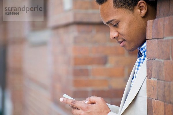 Junge Geschäftsleute in der Stadt SMS auf dem Smartphone