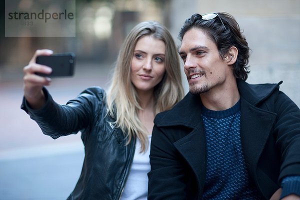 Selbstporträt eines Paares mit einem Smartphone auf der Stadtstraße