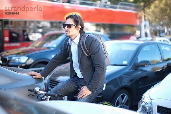 Mittlerer Erwachsener Geschäftsmann  der während der Hauptverkehrszeit Fahrrad fährt.