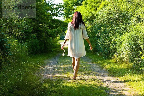 Rückansicht einer jungen Frau  die barfuß auf dem Landweg spazieren geht  Delaware Canal State Park  New Hope  Pennsylvania  USA