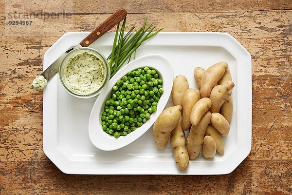 Fingerkartoffeln und Frühlingserbsen serviert mit einer Schnittlauchbutter