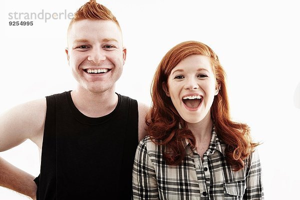 Studioporträt eines rothaarigen jungen Paares beim Lachen