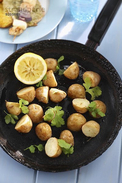 Bratkartoffeln mit Koriandergrün in der Pfanne