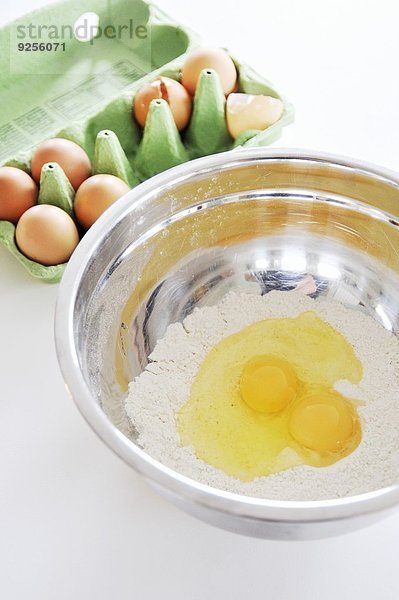 Mehl und aufgeschlagene Eier in Rührschüssel