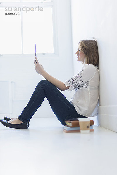 sitzend junge Frau junge Frauen benutzen Boden Fußboden Fußböden Tablet PC