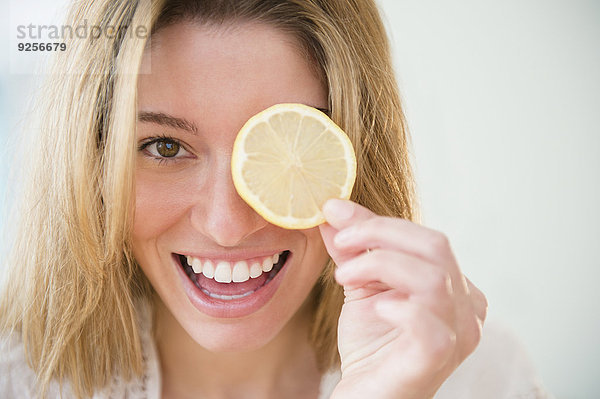 junge Frau junge Frauen Portrait halten Scheibe Zitrusfrucht Zitrone