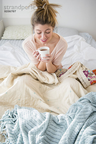 sitzend junge Frau junge Frauen Bett Kaffee
