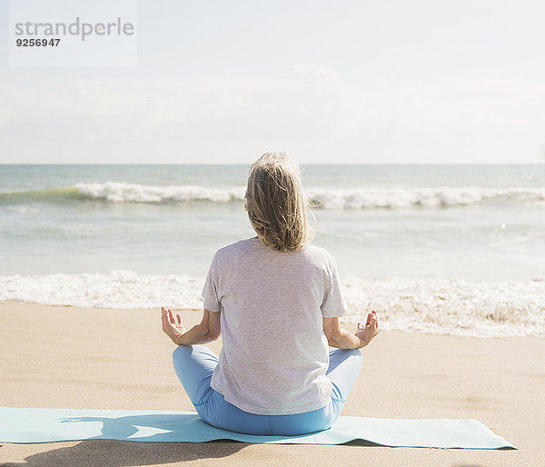 Senior Senioren Frau Strand üben Yoga