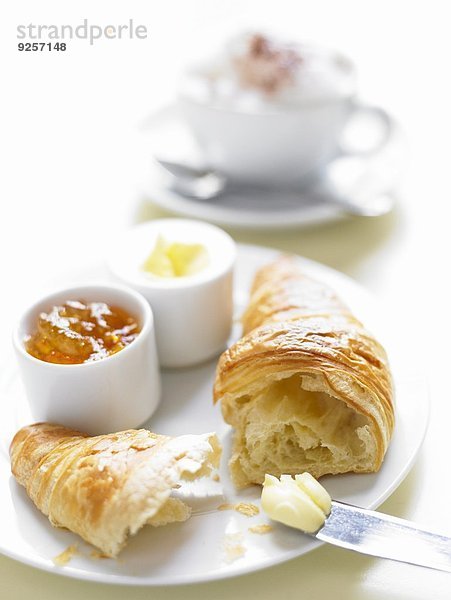 Frisches Croissant mit Butter und Marmelade