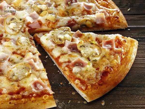 Pizza mit Schinken und Champignons  angeschnitten