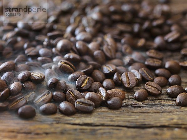 Viele Kaffeebohnen auf Holzuntergrund