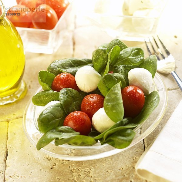 Spinatsalat mit Mozzarellakugeln und Tomaten  Olivenöl