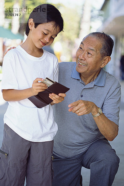Senior Senioren Mann geben Enkelsohn Geld