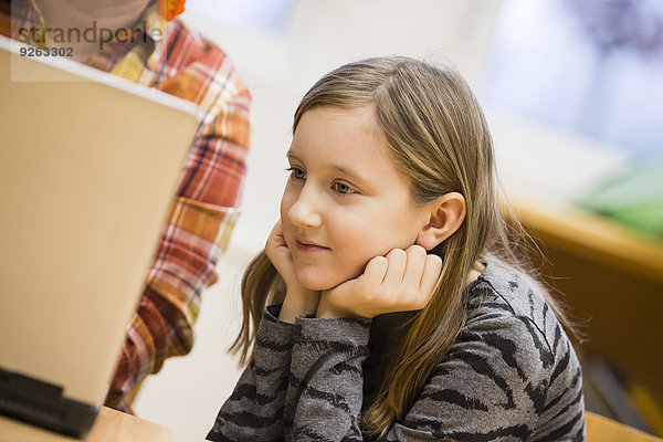 Porträt einer Schülerin beim Blick auf den Laptop