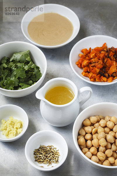 Schalen mit Zutaten von Karotten-Fenchel-Hummus auf Metall