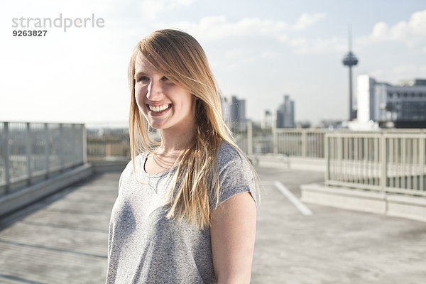 Deutschland  Nordrhein-Westfalen  Köln  Porträt einer lächelnden jungen Frau auf Parkebene
