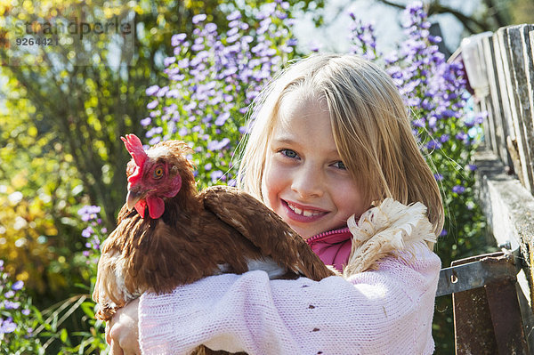 Fröhliche Mädchen umarmende Henne