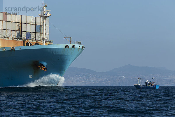 Spanien  Andalusien  Tarifa  Containerschiff und Fischerboot