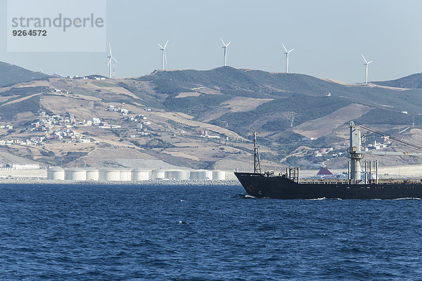 Marokko  Tanger  Straße von Gibraltar  Frachtschiff  Windpark und Raffinerie an der Küste