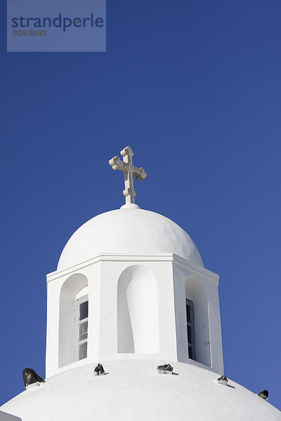 Griechenland  Kykladen  Santorini  Kuppel mit Kruzifix einer weißen Kirche vor blauem Himmel