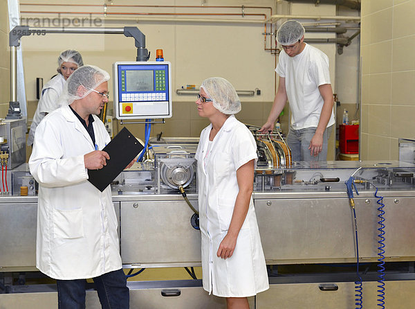 Deutschland  Sachsen-Anhalt  Mitarbeiter im Gespräch über Arbeitsabläufe in einer Backfabrik