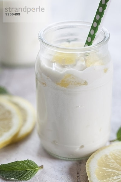 Zitronenjoghurt mit Zitronenscheiben und Minzeblättern